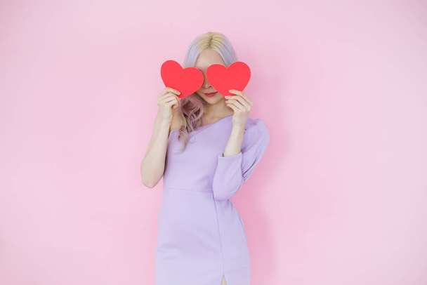 Portrait beautiful asian woman on pink background, happy valentine day in love concept, model holding red heart sign in hand - Foto, immagini