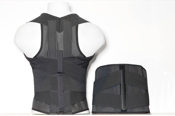 Lumbosacral support with a belt in the form of a corset on a mannequin for the prevention of acute and chronic pain in the lumbosacral region. Copy space. - Photo, Image