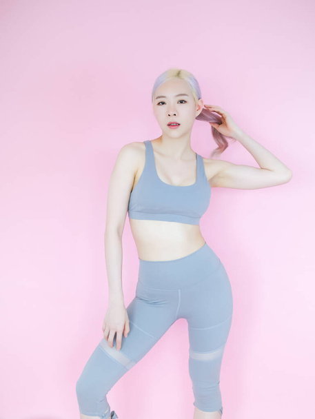 hermosa mujer asiática en rosa fondo, fitness deportes y recreación concepto - Foto, Imagen