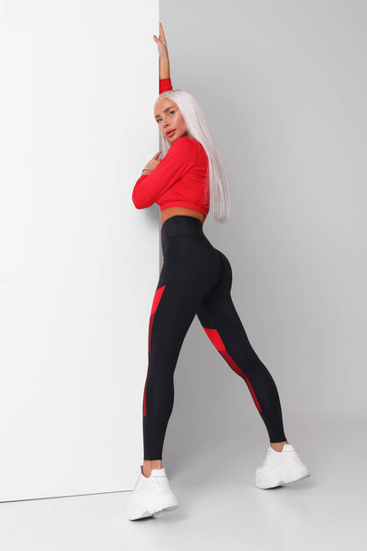 Beautiful fitness woman in leggings. Athletic girl on the gray background - 写真・画像