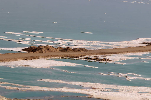 Οι ακτές της Νεκρής Θάλασσας στην έρημο της Ιουδαίας στα σύνορα μεταξύ Ισραήλ και Ιορδανίας. Κρύσταλλοι μεταλλικού αλατιού στην ακτή.  - Φωτογραφία, εικόνα