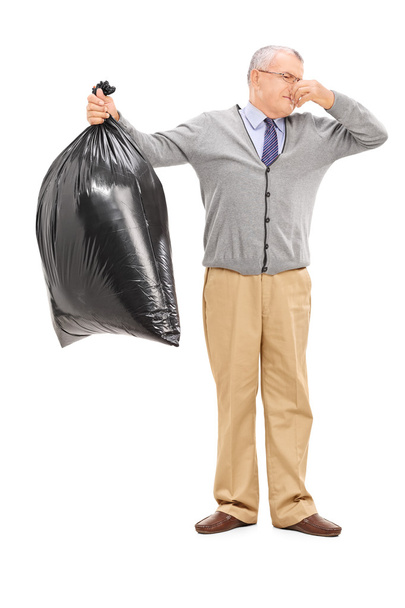 Senior holding stinky garbage bag - Φωτογραφία, εικόνα
