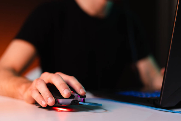 Main humaine appuyant sur la souris d'ordinateur avec flash de lumière sur fond - Photo, image