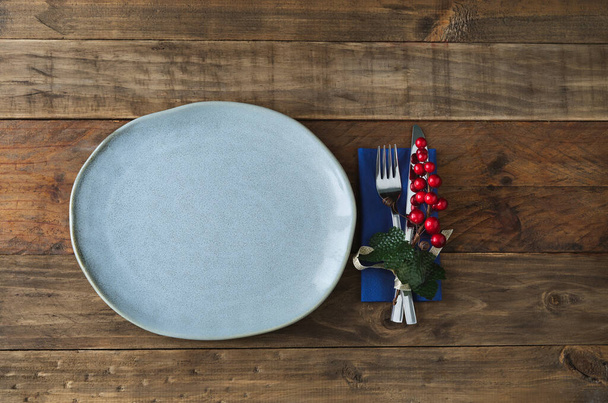 Rustic plate with Christmas decoration on the right side on wooden background. Copy space. - Fotoğraf, Görsel
