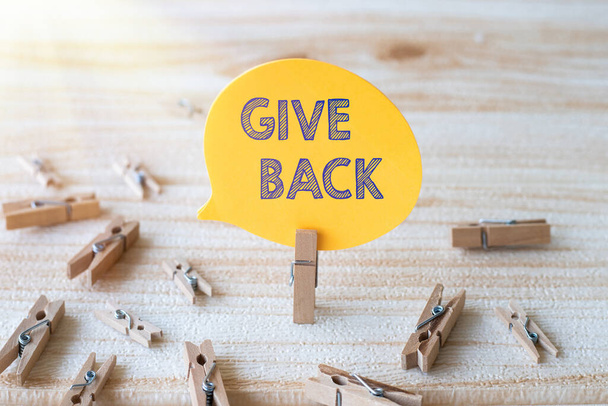 Handwriting text Give Back. Business concept the act of giving someone something that they owned or had before Piece Of Blank Speech Bubble Surrounded By Laundry Clips Showing New Idea. - Photo, Image