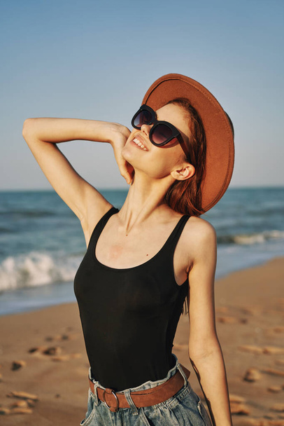 pretty woman in hat and sunglasses on the beach walk sun - Foto, afbeelding