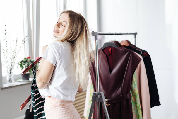 Beautiful young woman choosing clothes - Фото, зображення