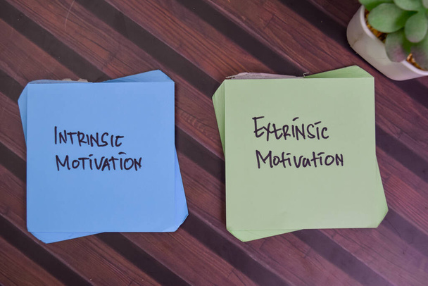 Intrinsic Motiváció és Extrinsic Motiváció írni ragacsos megjegyzések elszigetelt fa asztal. - Fotó, kép