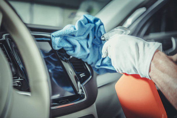 Uomini pulizia moderna cruscotto auto utilizzando detergente per la pulizia speciale. Manutenzione interna del veicolo. - Foto, immagini