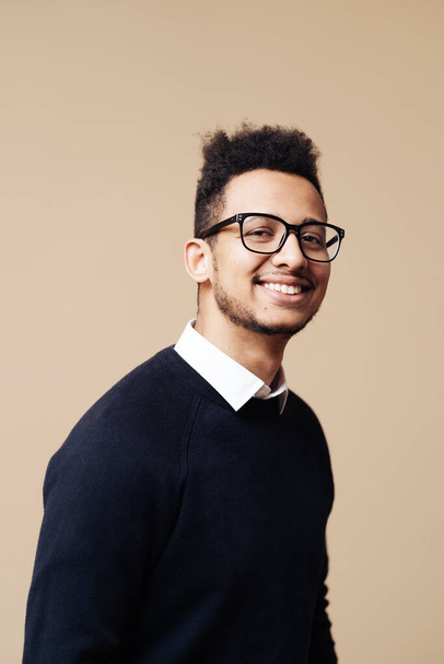 Afro Good looking guy in black sweater and glasses posing on beige background - Photo, Image