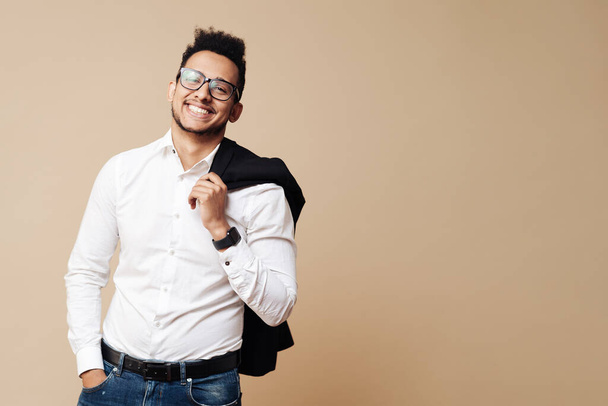 Afro Good looking guy in white shirt and glasses posing on beige background - Photo, image