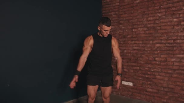Een jonge gespierde man in demonstreert zijn grote biceps en buikblokjes. Sport en gezonde levensstijl - Video
