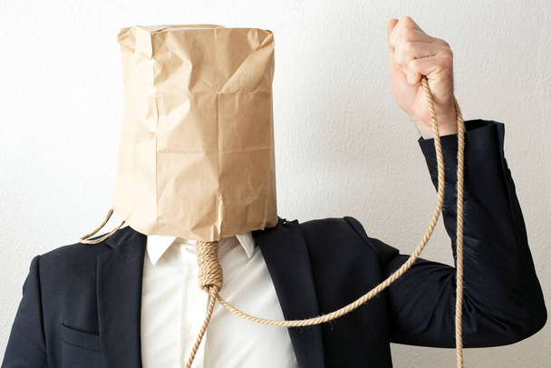business man with a paper bag on it's head, and a jute rope around his neck   - Φωτογραφία, εικόνα