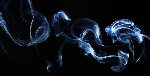 blue smoke on black background with abstract blur motion wave swirl . Wisp of Smoke. Cigarette smoke waves and clouds  texture - Zdjęcie, obraz