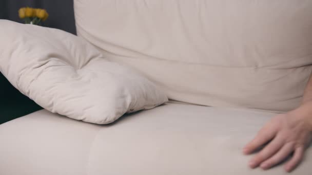 Muž ve spánkové masce padá na pohovku vyčerpaný, detailní záběr - Záběry, video