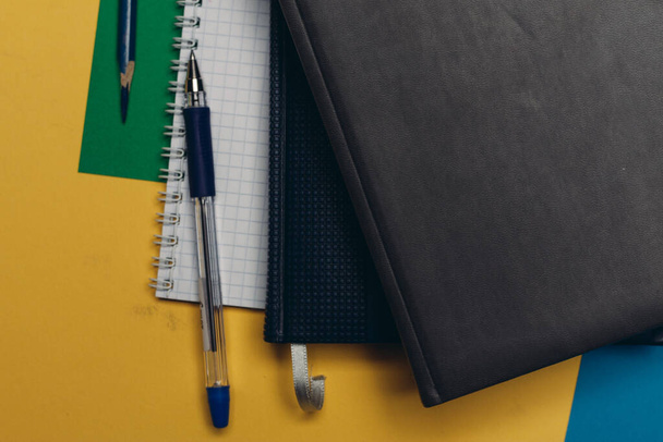 black notepad pencil colorful background office supplies - Foto, Imagen