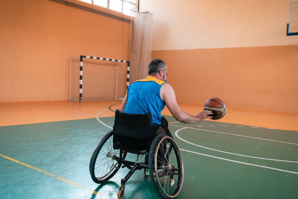 Close up photo of wheelchairs and handicapped war veterans playing basketball on the court. Selective focus  - Fotografie, Obrázek