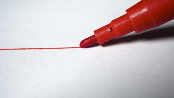 Beyaz kağıt üzerinde keçeli kalemle kırmızı bir çizgi. Kapat. - Video, Çekim