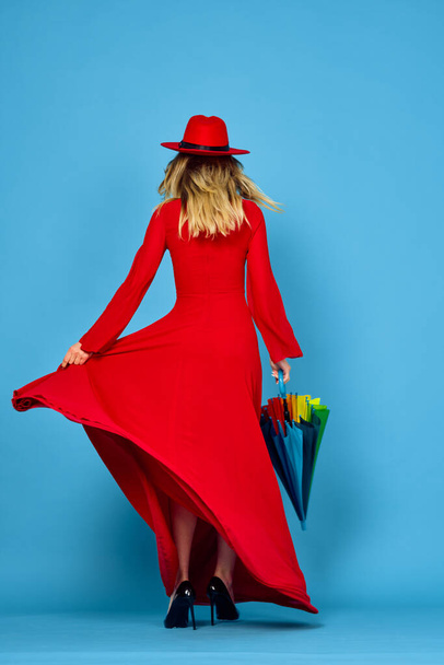 woman in red dress multicolored umbrella blue background - Photo, Image