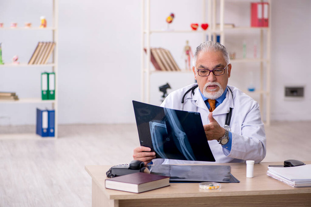 Old male doctor radiologist working in the clinic - Photo, Image