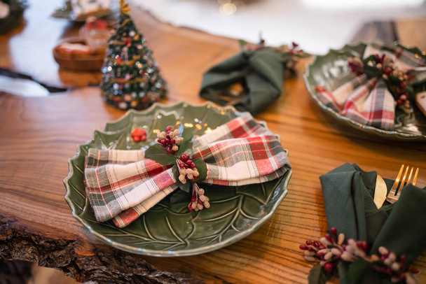 Karácsonyi asztal beállítás karácsonyi dekoráció és tányérok, sárkány, villa és kanál. Karácsonyi ünnepi háttér. Felülnézet másolási hellyel. - Fotó, kép