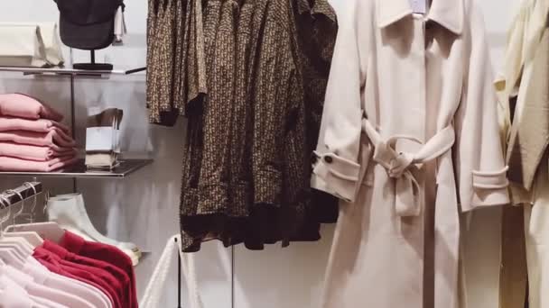 Ruházati kiskereskedelem és fenntartható divat koncepció. Luxus női ruházat választék, őszi és téli kollekció a tömegpiaci márkaboltban - Felvétel, videó