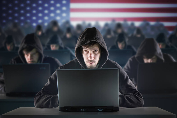 Многие американские хакеры на ферме троллей. Концепция безопасности и киберпреступлений. Флаг США на заднем плане. - Фото, изображение