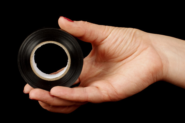 Woman hand holding black electric insulating tape - Photo, Image