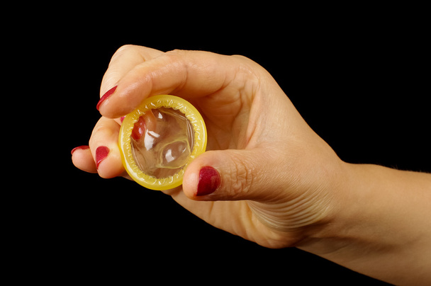 γυναίκα χέρι που κρατά το προφυλακτικό ως ένα δαχτυλίδι που απομονώνονται - Φωτογραφία, εικόνα