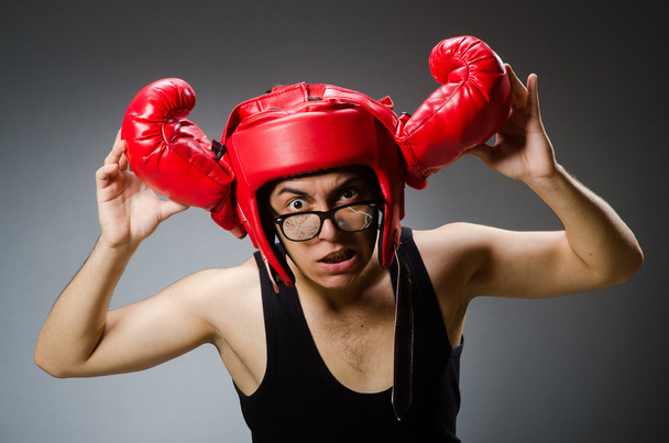 Boxeador divertido con guantes rojos sobre fondo oscuro - Foto, Imagen