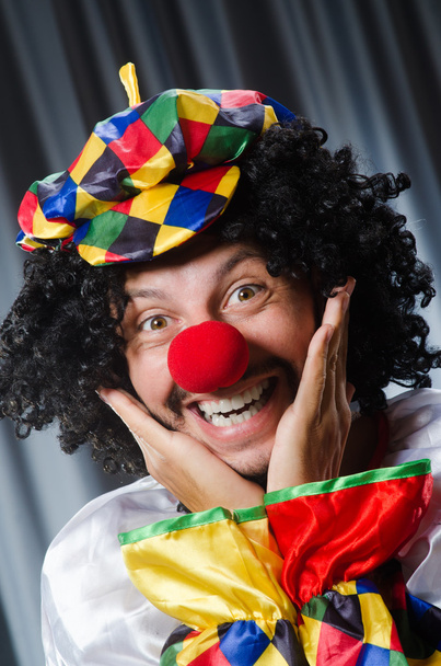 Lustiger Clown mit humorvollem Konzept gegen Vorhang - Foto, Bild