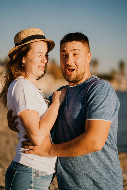 Een man en een verliefde vrouw die op het strand lachen. pasgetrouwden in het resort.  - Foto, afbeelding