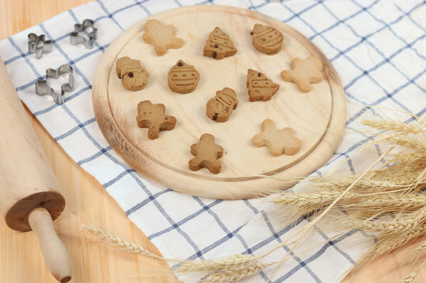 Σπιτικά μπισκότα ψωμιού τζίντζερ, μπισκότο τζίντζερ σε ξύλινο δίσκο, προετοιμασία αρτοποιίας, διαδικασία ψησίματος και μαγειρέματος στο σπίτι. - Φωτογραφία, εικόνα