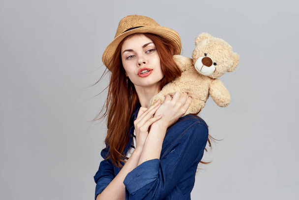 cheerful woman in a hat with a teddy bear gift toy - Foto, imagen