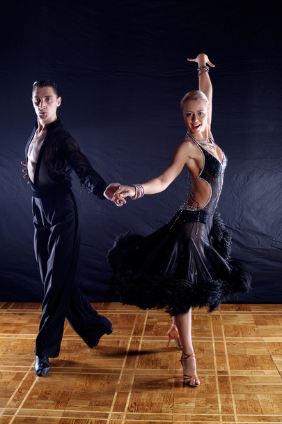 Dancers in ballroom against black background - Foto, afbeelding