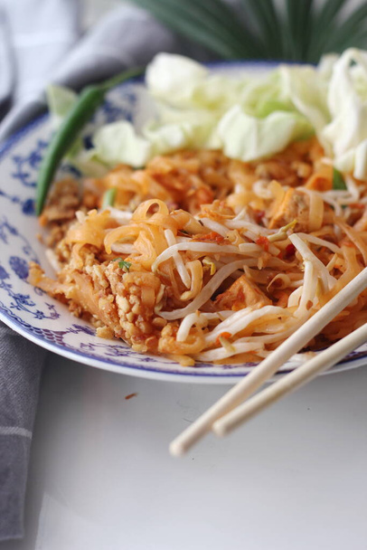 Thai food Pad Thai (national dish) served in a Chinese-style patterned bowl. Place it on a white table. - Photo, Image