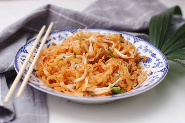 Thai food Pad Thai (national dish) served in a Chinese-style patterned bowl. Place it on a white table. - Photo, Image
