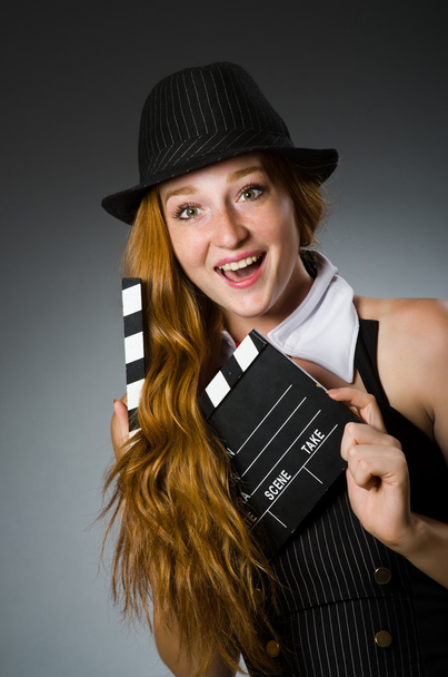 Mujer con clapboard de película sobre fondo gris - Foto, Imagen