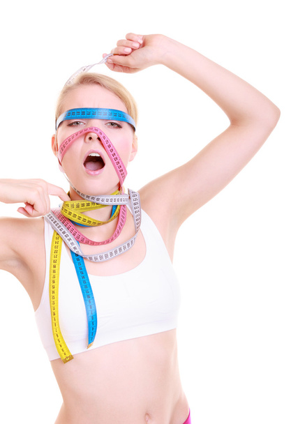 Obsessed fitness woman with a lot of colorful measure tapes - 写真・画像