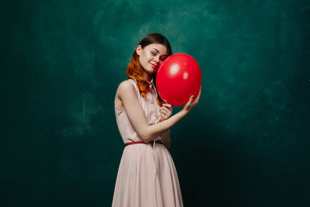 cheerful woman with red balloon green background holiday - Φωτογραφία, εικόνα