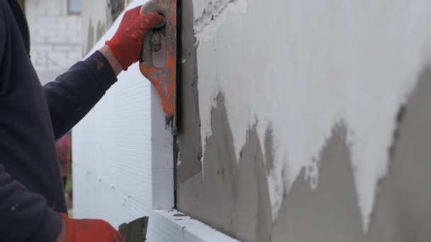 Építőipari munkás borító ház fala ragasztóval cement ragasztó berore telepítése styrofoam szigetelő lapok hővédelem - Felvétel, videó