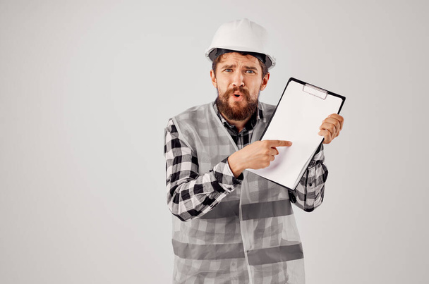 mężczyzna budowniczy w biały kask plany Profesjonalne lekkie tło - Zdjęcie, obraz