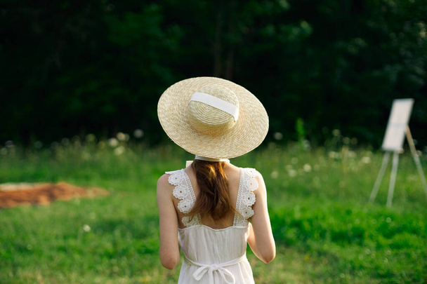 pretty woman in white dress outdoors easel art - Φωτογραφία, εικόνα