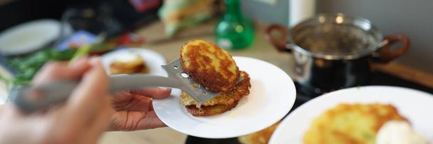 Kokki valmistaa paistettuja perunapannukakkuja paistinpannulla lähikuva - Valokuva, kuva