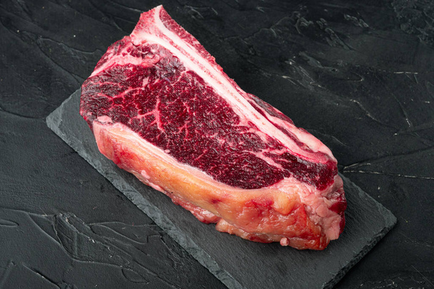 Raw beef club steak dry aged set, on black stone background - Фото, изображение