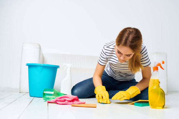 woman near the sofa cleaning supplies protective gloves - 写真・画像
