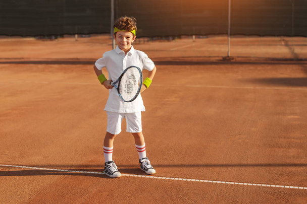 Boy with tennis racket on court in summer - Zdjęcie, obraz