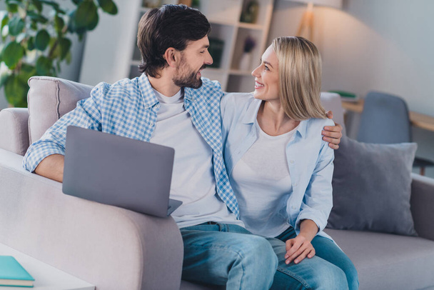 Photo of funny lover couple sit couch cuddle rest enjoy weekend wear casual outfit in comfortable home indoors - Φωτογραφία, εικόνα