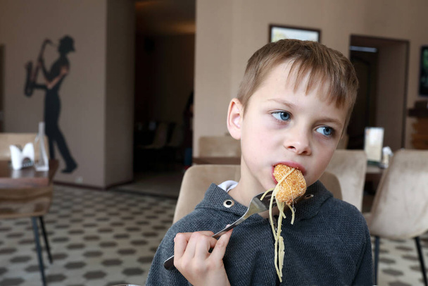 Child has nuggets with pasta in restaurant - Фото, изображение