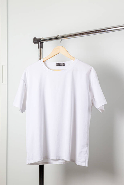 白いTシャツのモックアップ服ハンガーに。ベラキャンバスモックアップ最小限のスタイルで. - 写真・画像